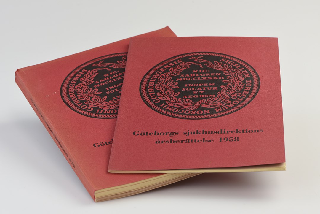 Två röda böcker. Göteborgs stads sjukhusdirektions årsberättelse med Sahlgrenska sjukhusets sigill från 1790 på omslaget. 