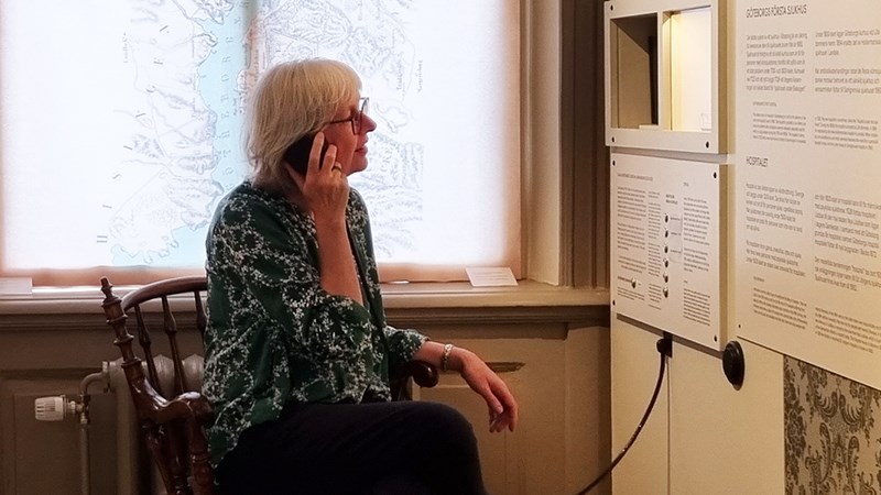 En person lyssnar på ljudspår i museets utställningar