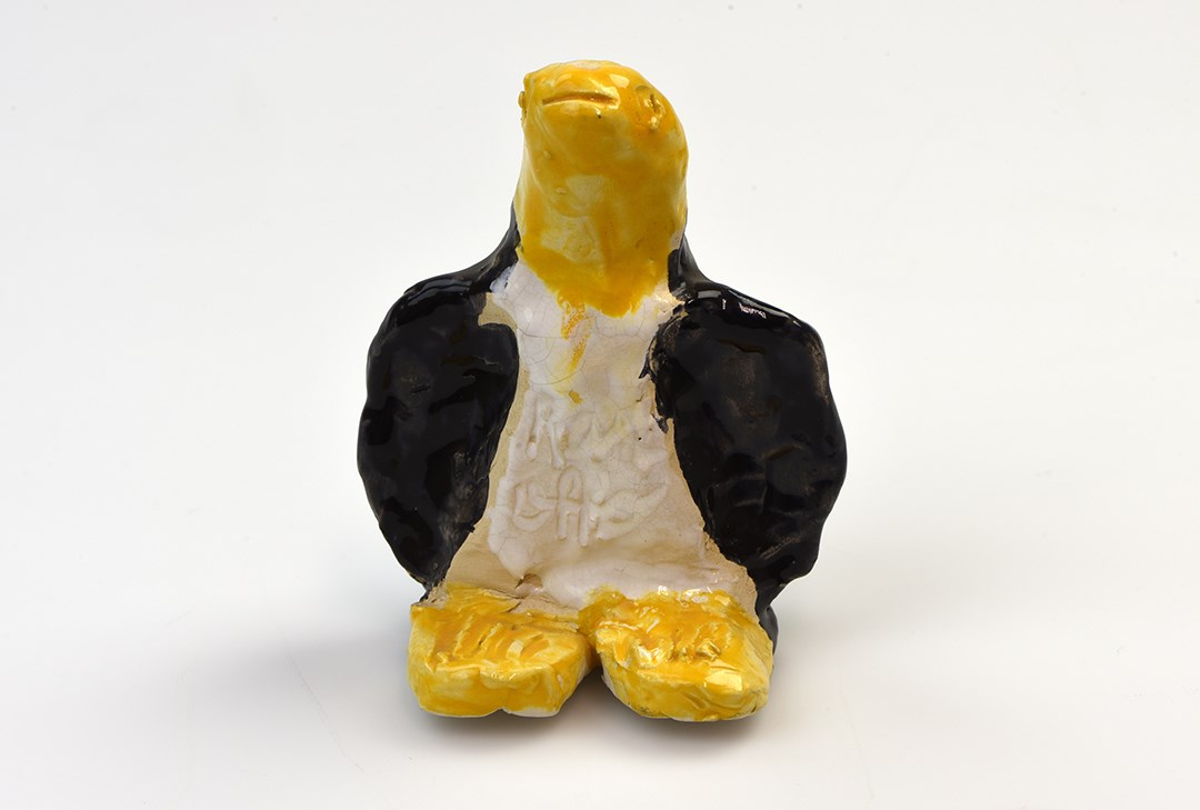 Glaserad keramikfigur, gul och svart